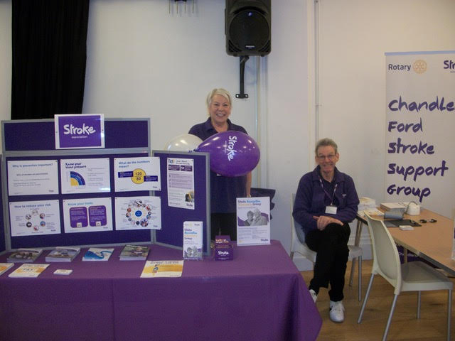 Two woman behind a Stroke Association exhibition. 