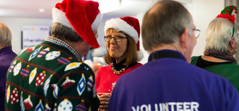 Several people wearing Christmas jumpers and hats