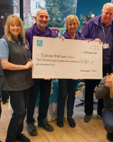 Members of Stubbington Stroke Support Group alongside Co-op staff, with 3 people holding a large card cheque