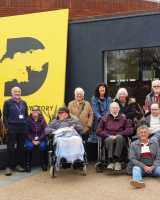 Several elderly people outside of the D-Day Story Museum's front entrance.