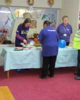 People gathered around an exhibition table with Stroke Association staff behind it.