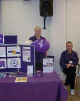 Two woman behind a Stroke Association exhibition. 